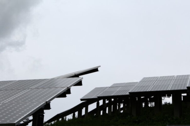 Bild 1 Photovoltaik-Anlage in den morgentlichen Nebelbänken der Berge.